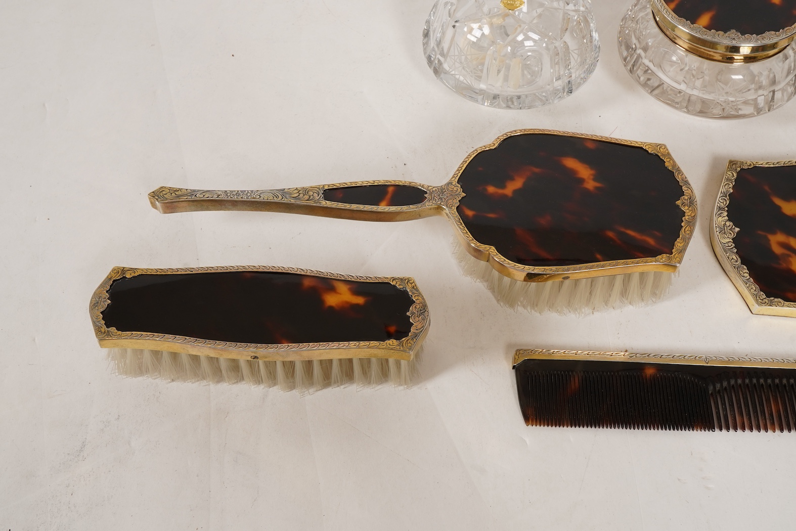 A mid 20th century continental eight piece gilt white metal and tortoiseshell mounted dressing table set